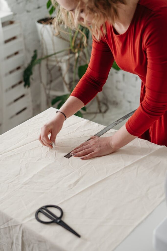 Woman in Red Long Sleeve Dress Holding White Textile